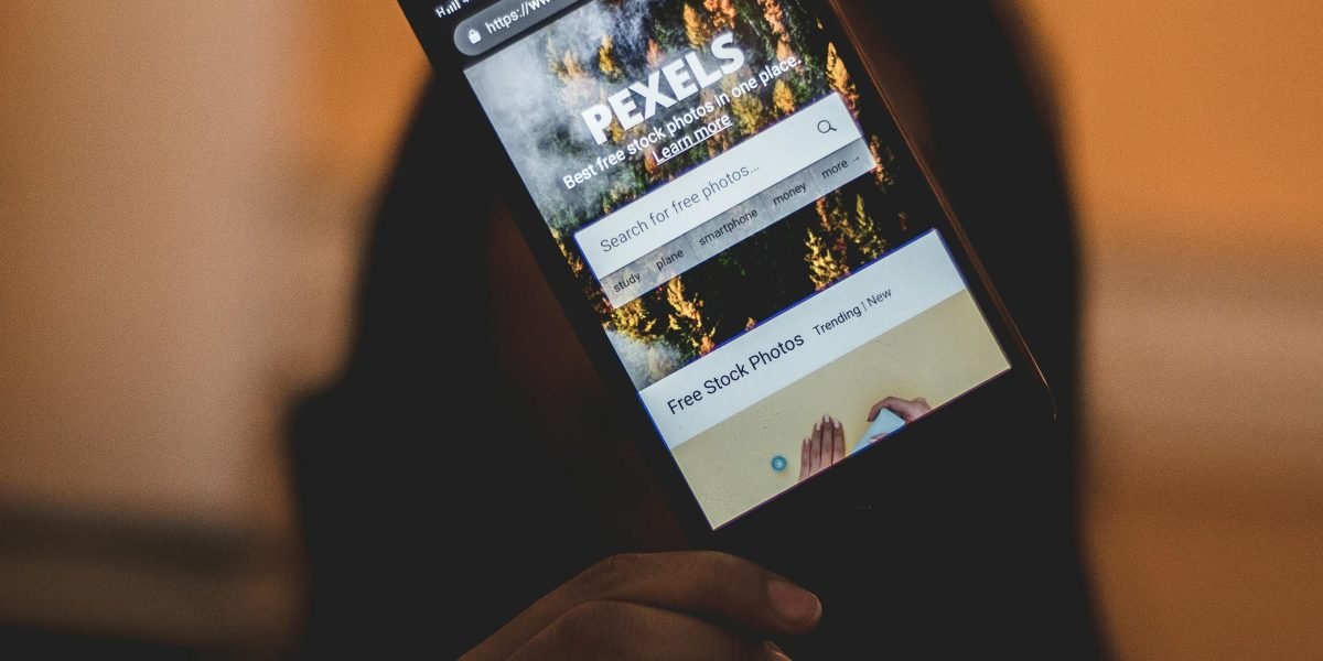 A person intently reviewing a website's layout and functionality on a smartphone.