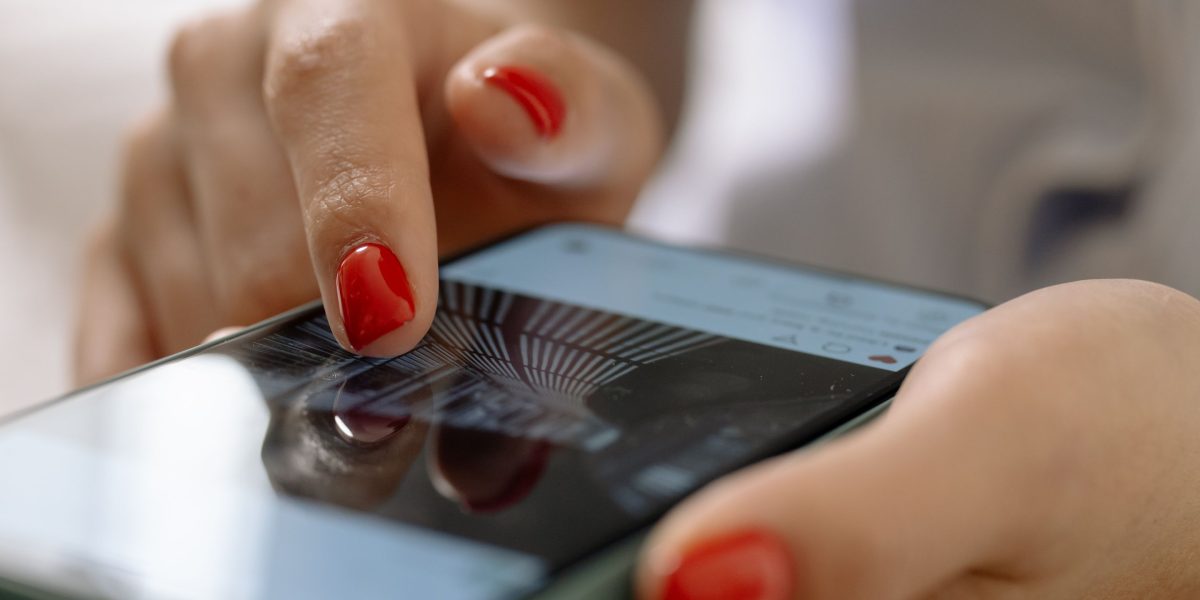 A person engaging with content on their phone, depicting audience behavior on social media platforms.