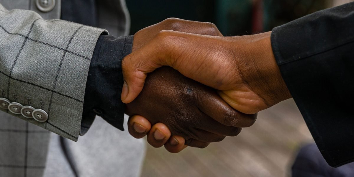 Two professionals shaking hands, signifying a successful partnership or collaboration.
