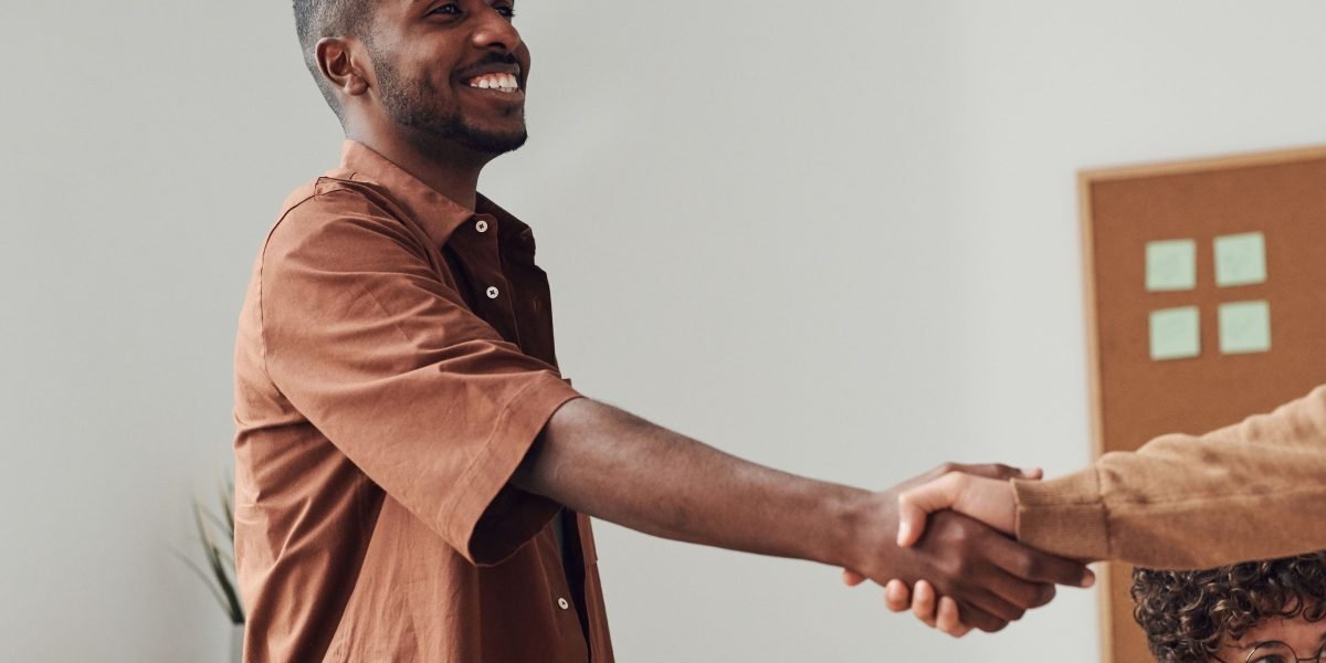 Two professionals shaking hands, symbolizing a successful partnership agreement between a real estate agent and a web agency.