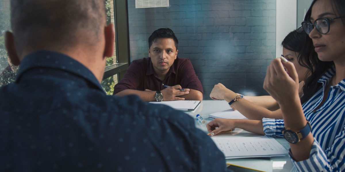 A team collaborating around a whiteboard, representing the continuous effort and strategic planning required for effective SEO.