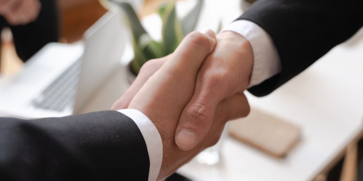 Professionals shaking hands, representing the formation of local partnerships for mutual benefit and link opportunities.