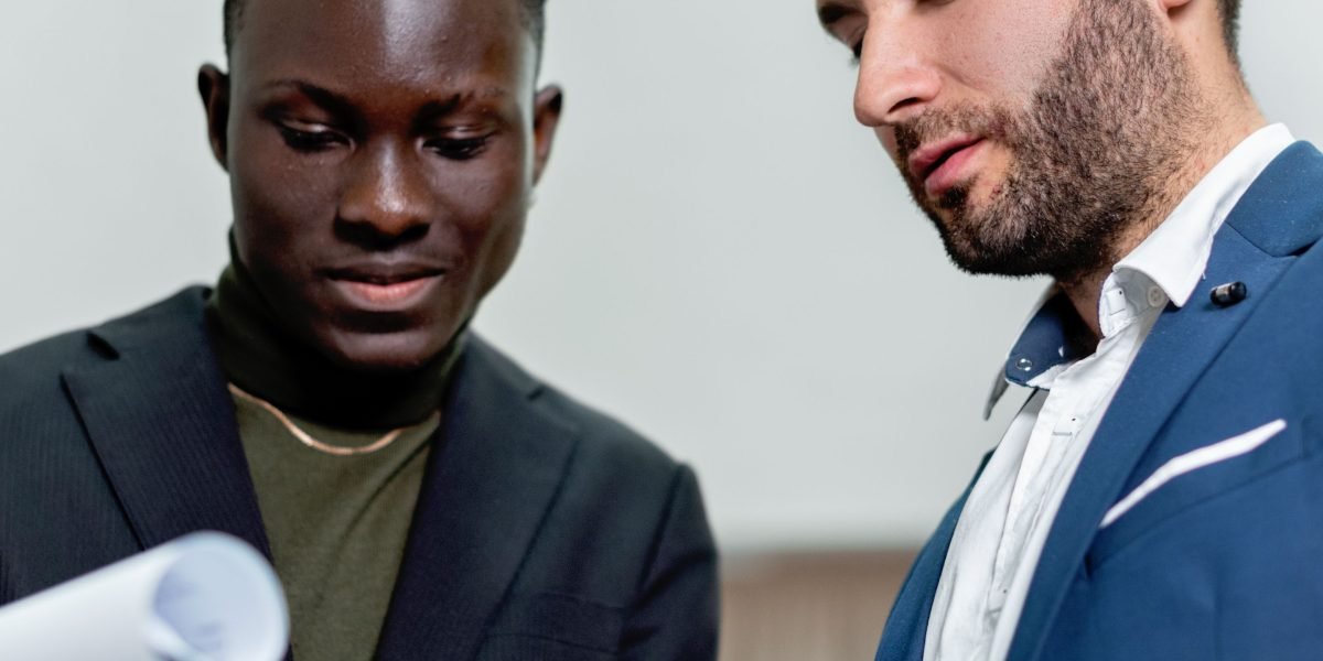 Professionals thoughtfully evaluating proposals and documents during a business meeting, emphasizing the importance of diligence.