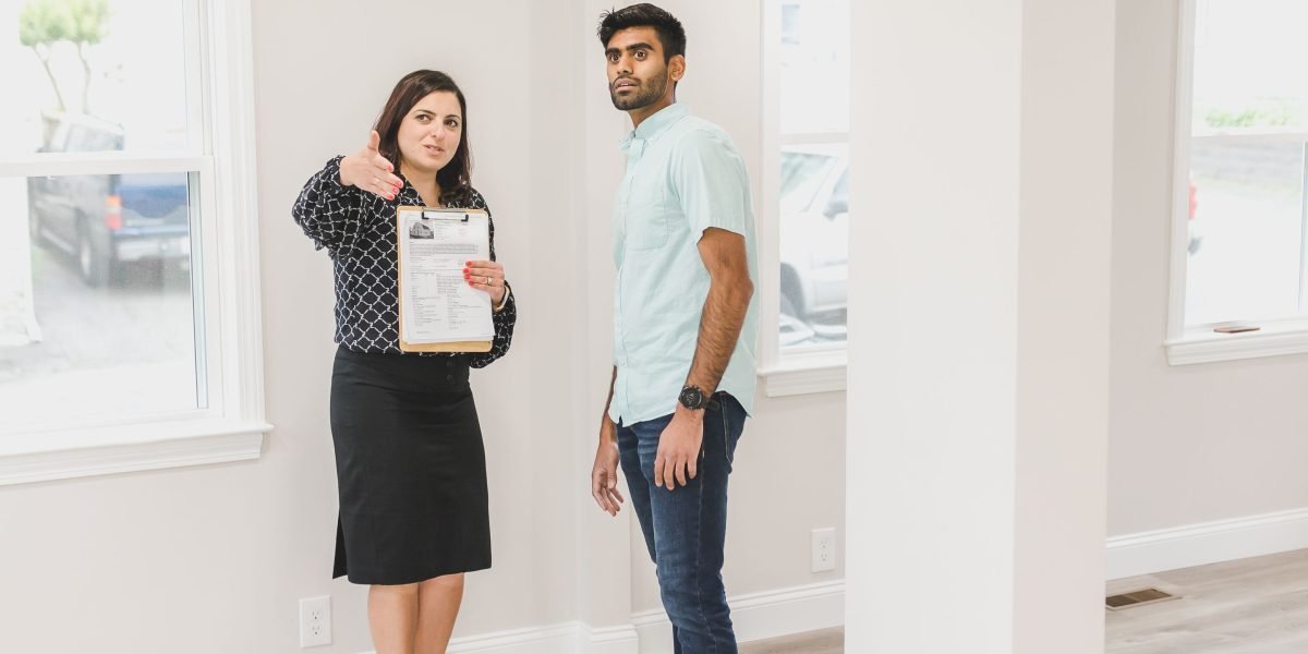 A real estate agent showing a property to happy clients, emphasizing the goal of high-converting website design.
