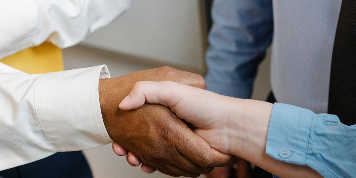 Two business professionals shaking hands, symbolizing successful partnerships and collaborations that enhance off-page SEO.