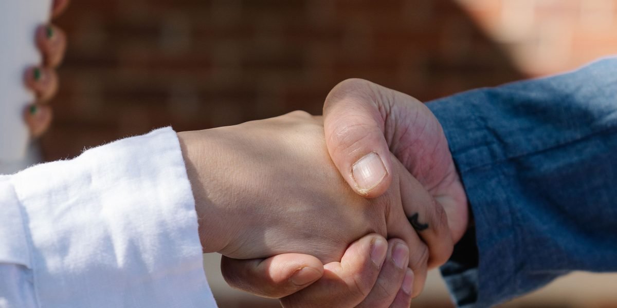 A real estate agent shaking hands with a client, symbolizing successful lead generation and client engagement.