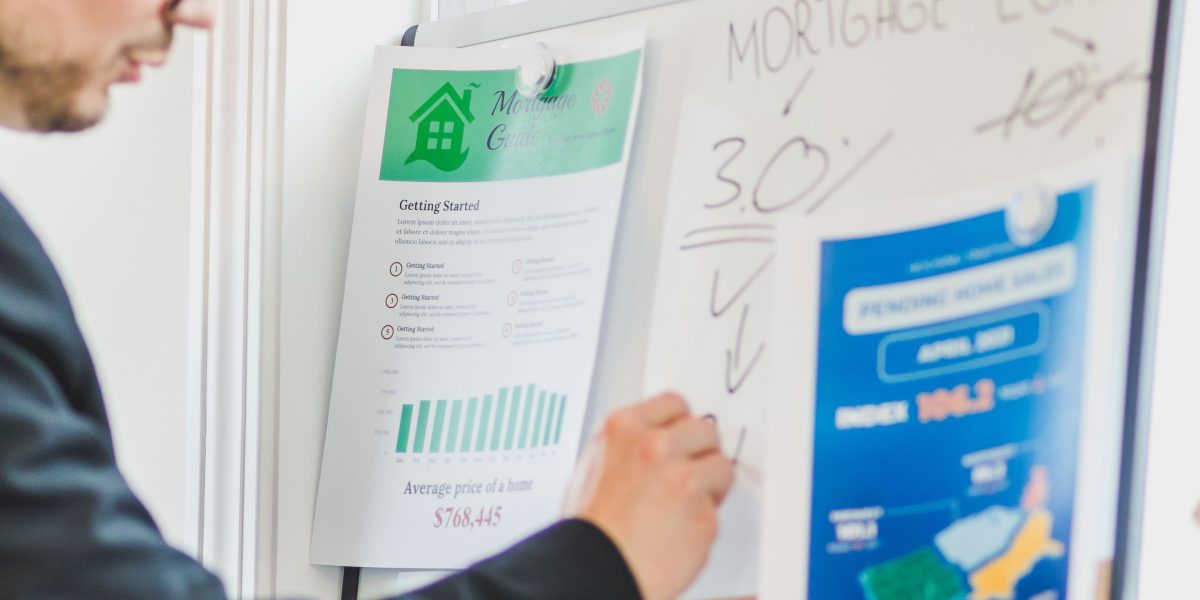 A confident real estate agent intently planning marketing strategies in a modern office setting, focused on standing out in a competitive market.