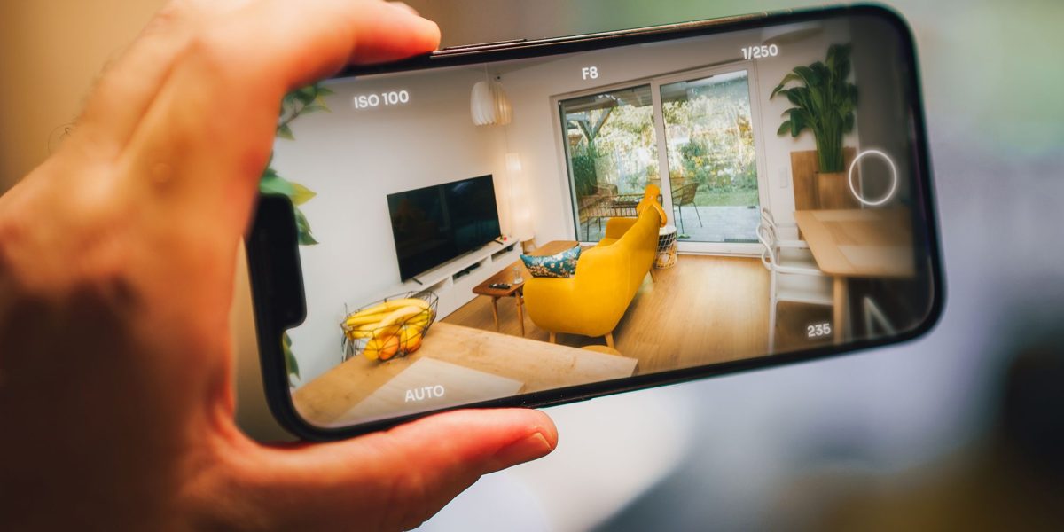 A real estate agent filming a property tour video with a smartphone, demonstrating content creation for engaging listings.